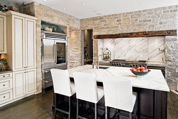 Polished marble tops the island and surrounds the cooktop area, where sliding panels hide storage.