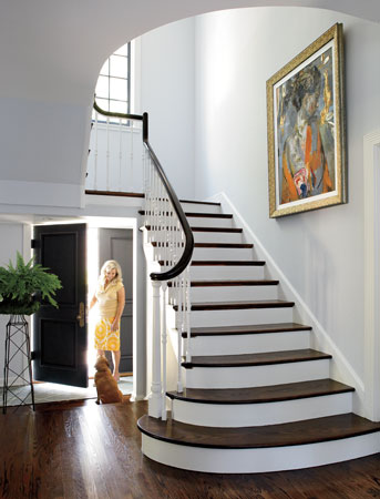 Judi Mills-Grossman and Reilly, the family’s puggle, contemplate a walk. She chose contemporary art for the foyer and other rooms; this painting is by Charles Dwyer. 