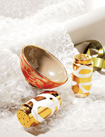 Waylande Gregory gold-and-white Lava salt and pepper shakers; L’Objet’s small ceramic bowl finished with 24-karat gold 