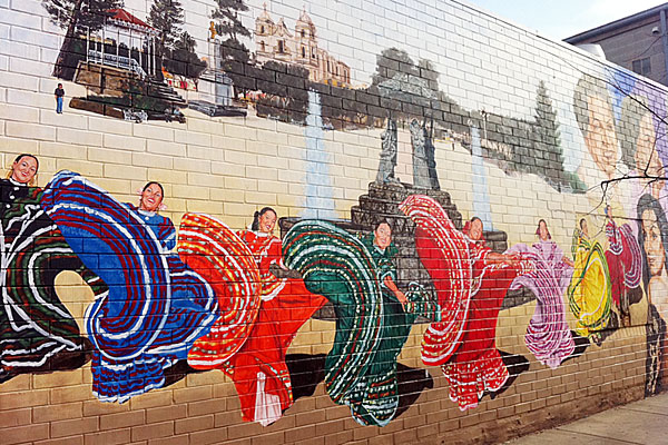 A mural featuring scenes of Latin American culture