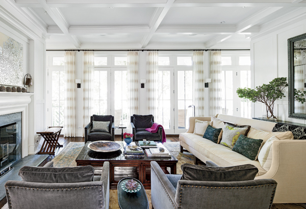 Gauzy drapes filter sunlight in the living room, where the soapstone fireplace is an elegant focal point.