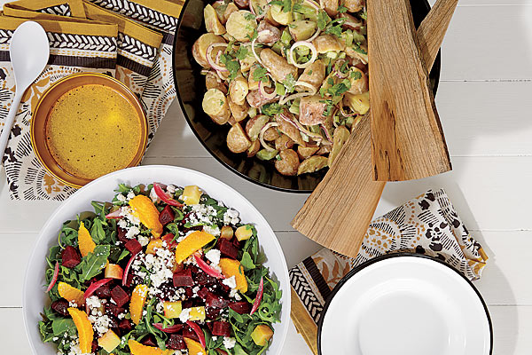 Cotton napkins, melamine serving utensils, melamine salad bowls, metallic bowl, and wooden salad servers