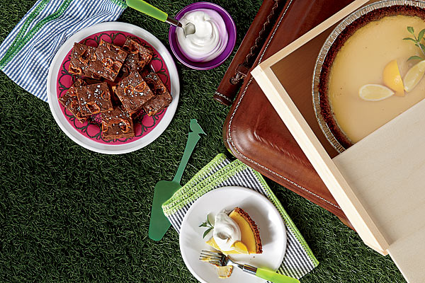 Cotton seersucker napkins, pink-printed melamine plate, melamine plates, stainless steel and rubber flatware, leather-covered cooler, wooden pie box, and natural resin pie server