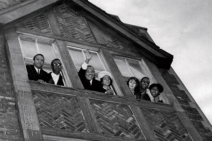 The Kings, accompanied by fellow activists, look out from their own apartment on South Hamlin Avenue in North Lawndale.