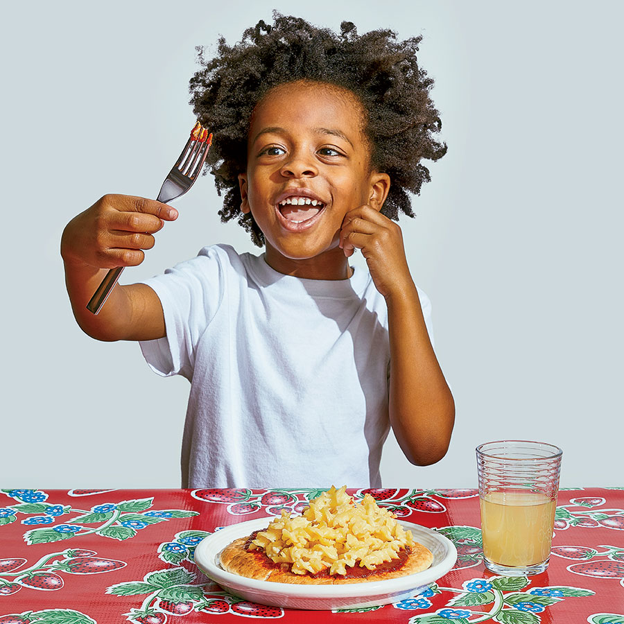 Zion eating Leftover Mac and Cheese Pizzas