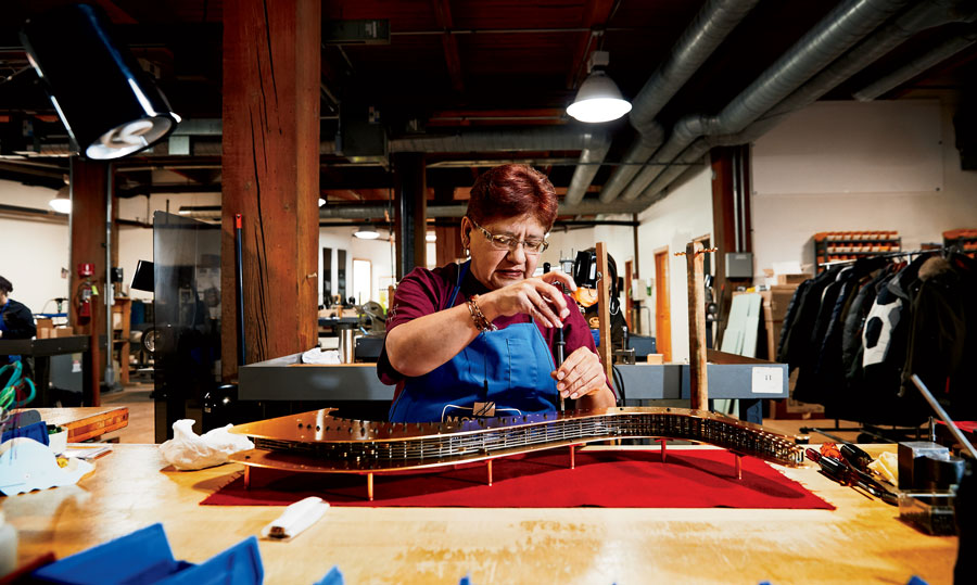 Maria Serna attaches the back plate to a mechanism, which holds 1,500 of the nearly 2,000 parts in a pedal harp.