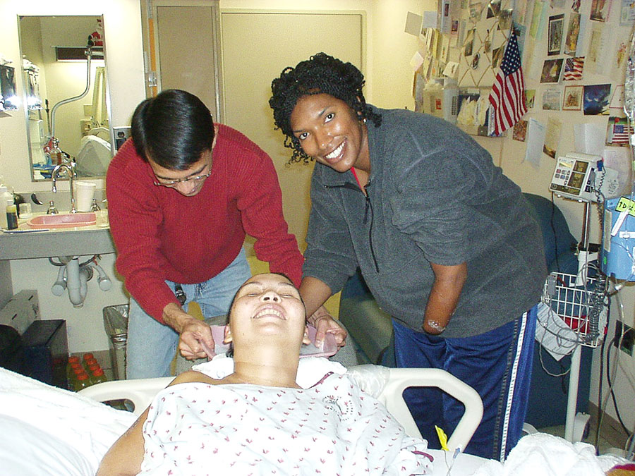 Sergeant First Class Juanita Wilson washing Duckworth's hair