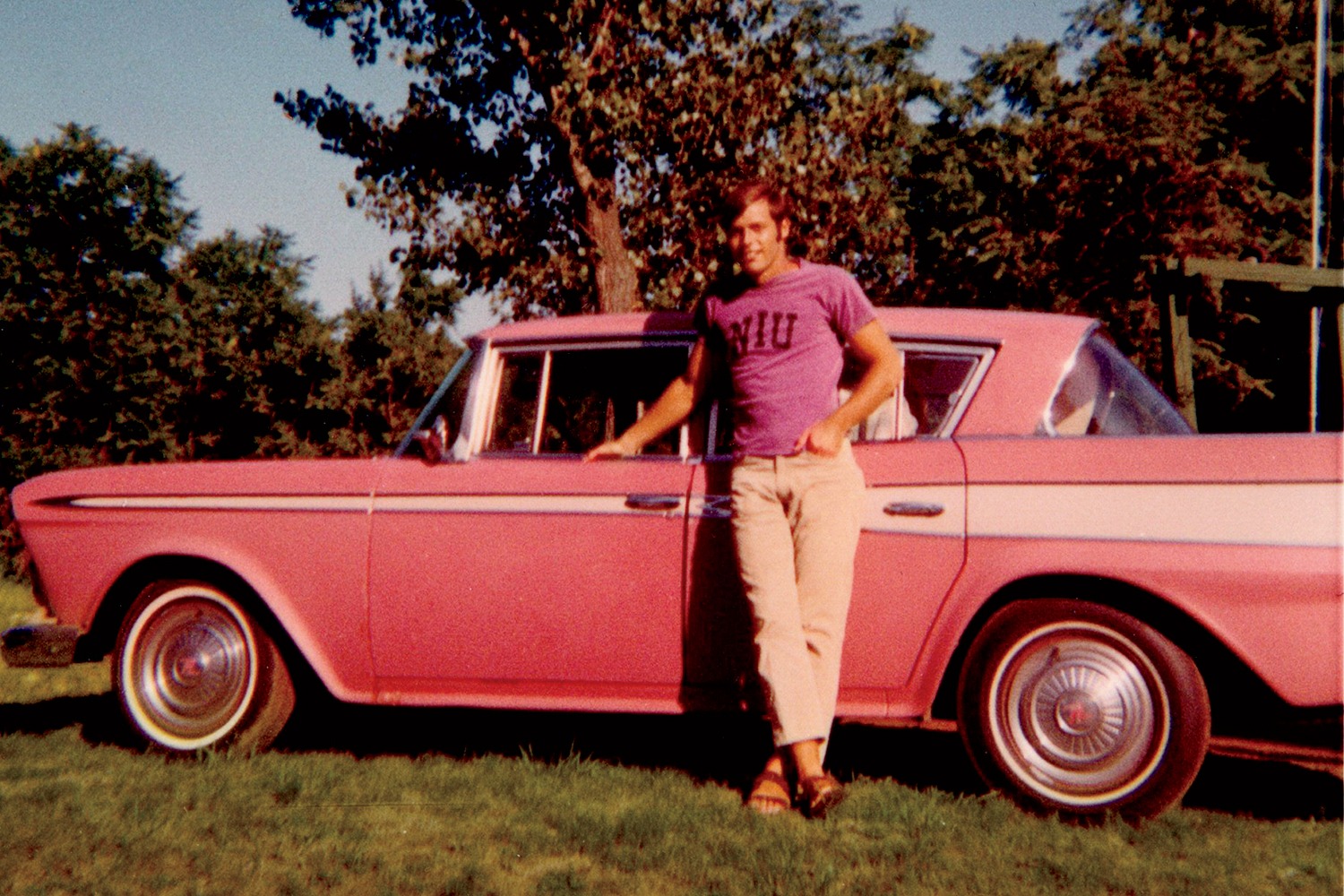 Man standing in front of pink car