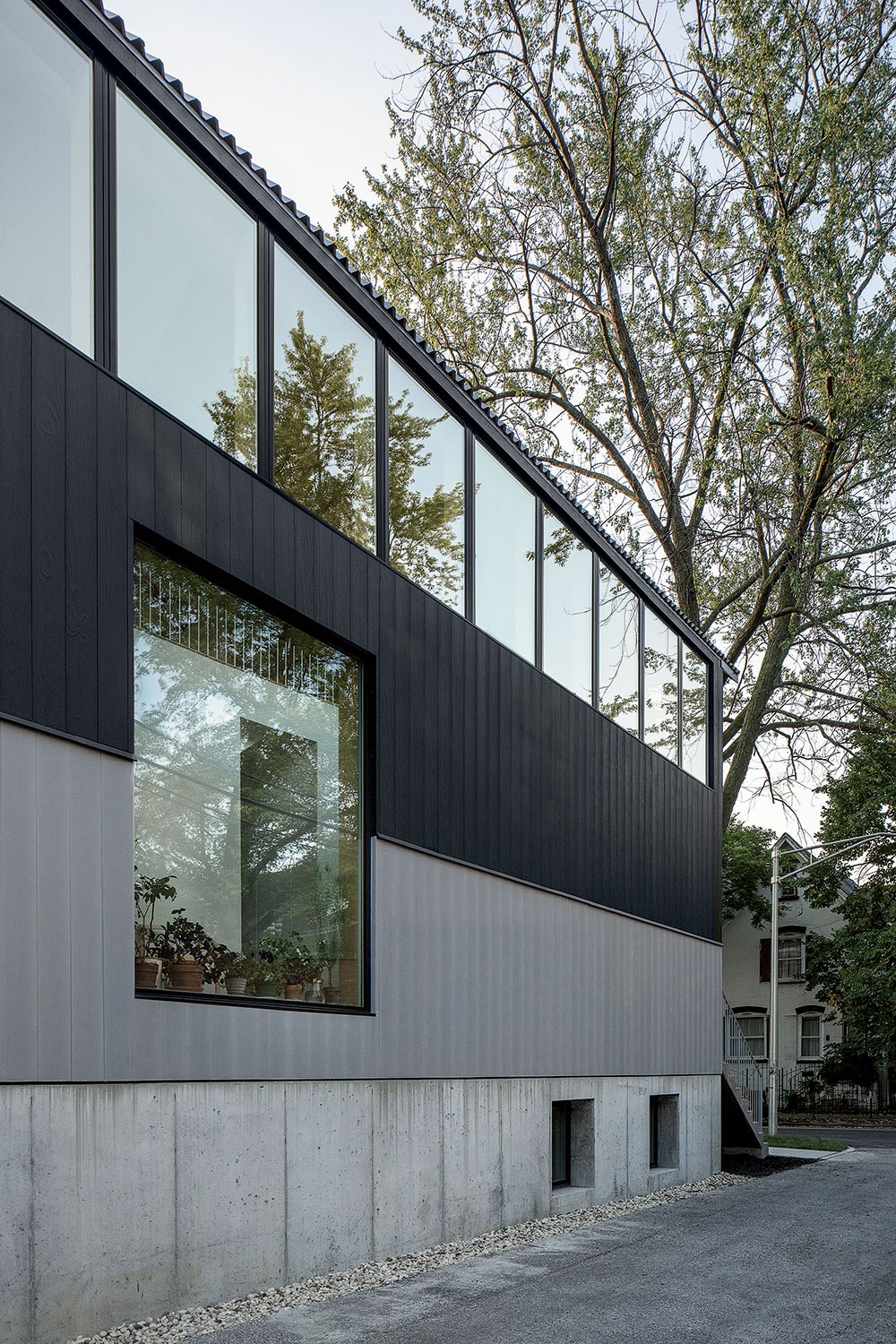 The concrete base and black-and-gray-painted wood frame above it are meant to emphasize the “flip” of the home, with the common spaces upstairs rather than on the main level. “The [exterior] colors don’t even line up with the floor plates,” Kwong says of the unusual layout.