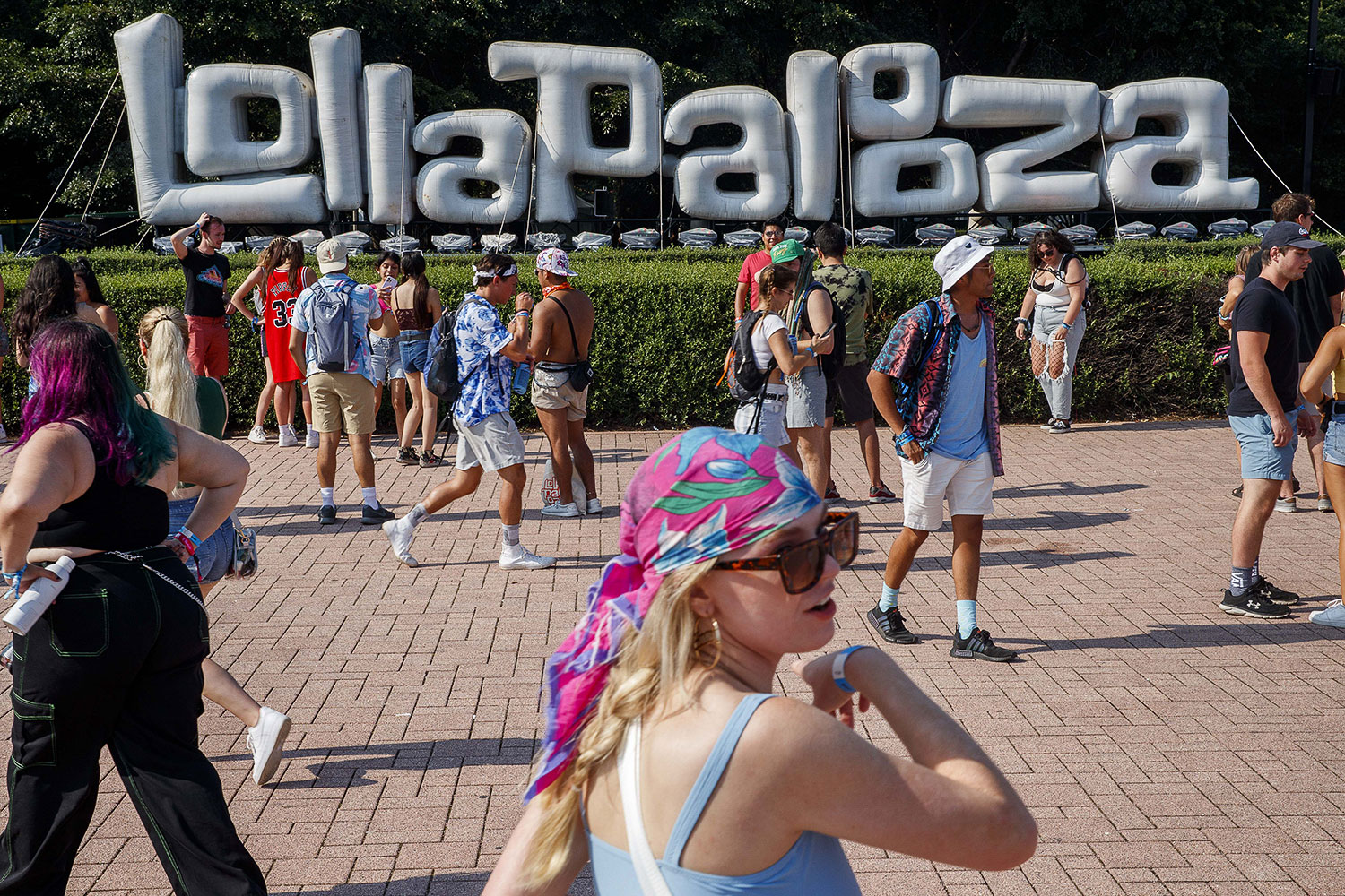 Attendees walk past a Lollapalooza sign during the first day of Lollapalooza in Grant Park Thursday July 29, 2021 in Chicago.