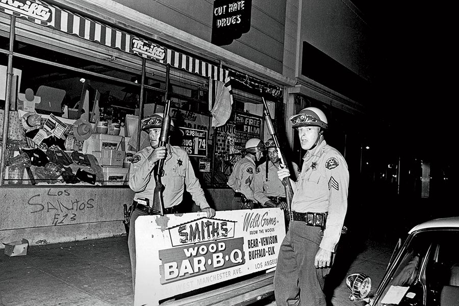 Police patrol the streets of Los Angeles’s Watts neighborhood in August 1965.