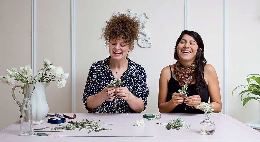 Emily Neumann and Carol Arteaga making flower arrangements