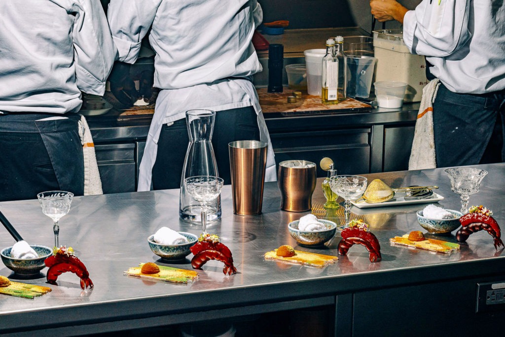 Chefs preparing dishes in the kitchen at Alinea