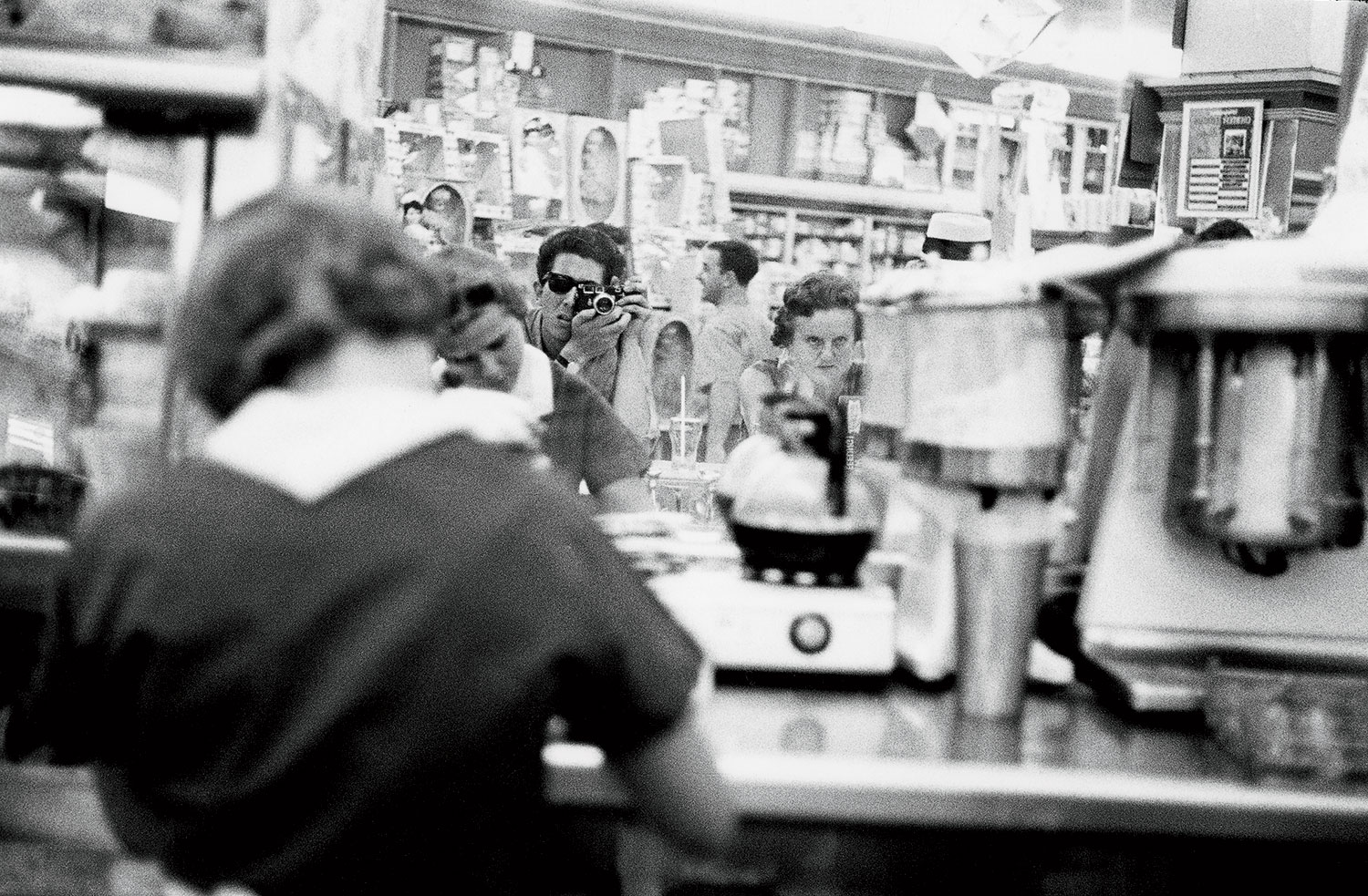 A 1964 photo of Jay King in the mirror of the busy Woolworth’s diner.
