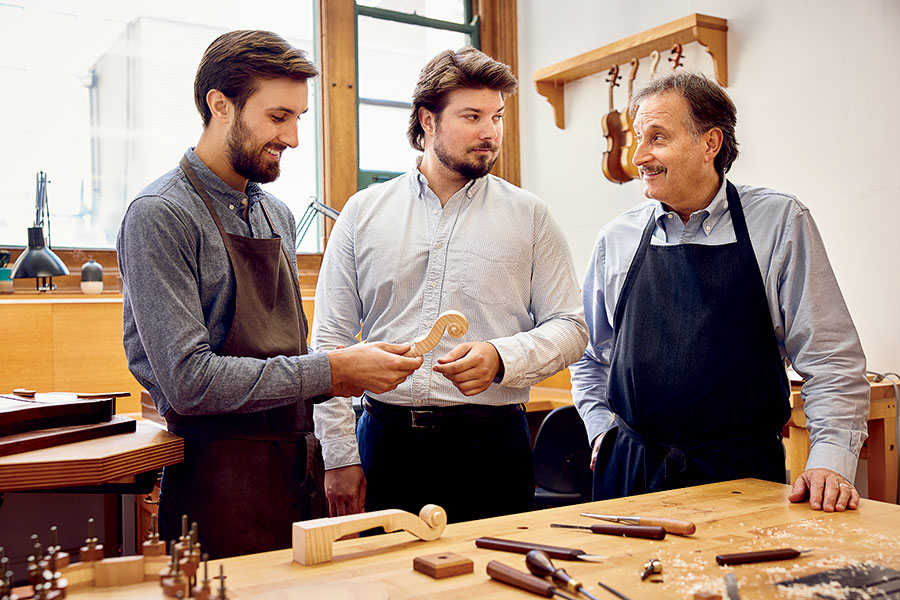 Becker’s son Garrett (left) makes Stradivarius-inspired violins of his own, while his brother, John Jr. (center), manages their father’s business.