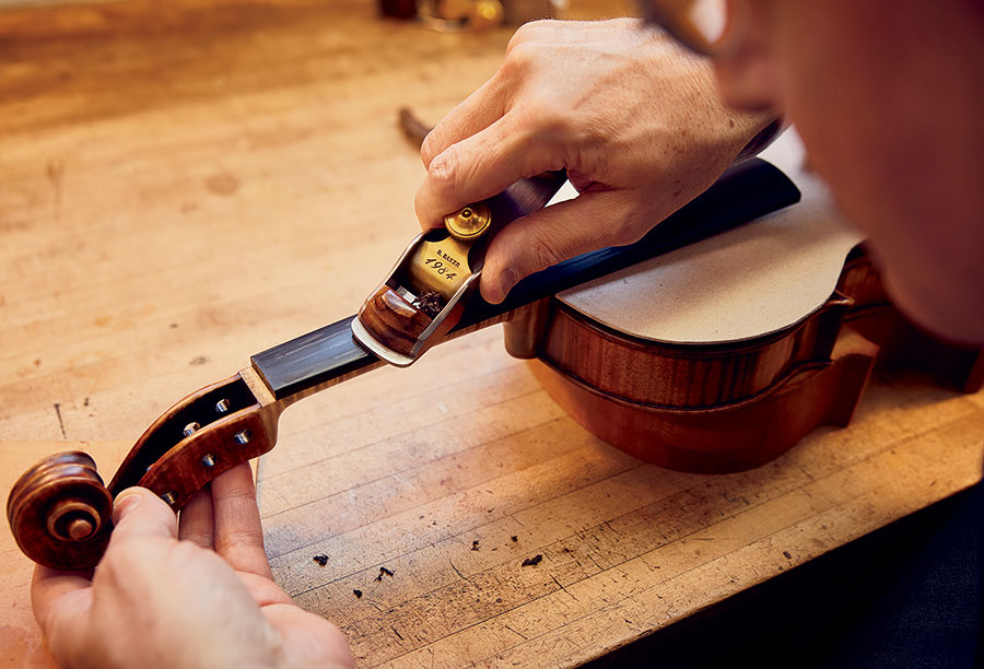 Becker planes the fingerboard of a 1694 Stradivarius.