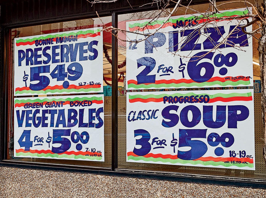 Painted signs in a grocery store window