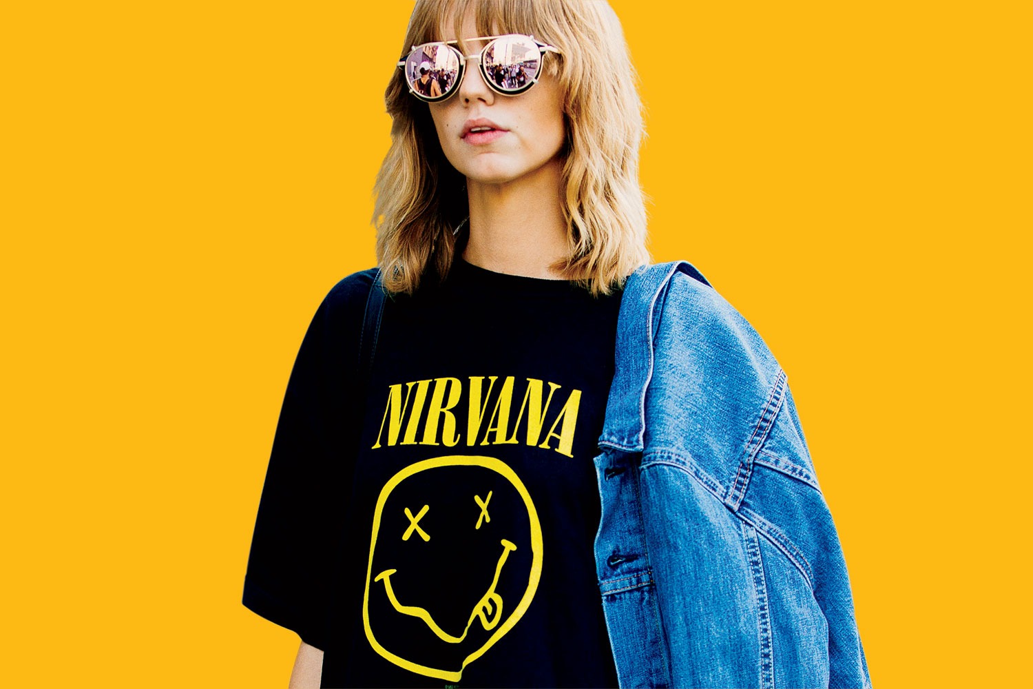 A woman in round sunglasses wearing a Nirvana t-shirt