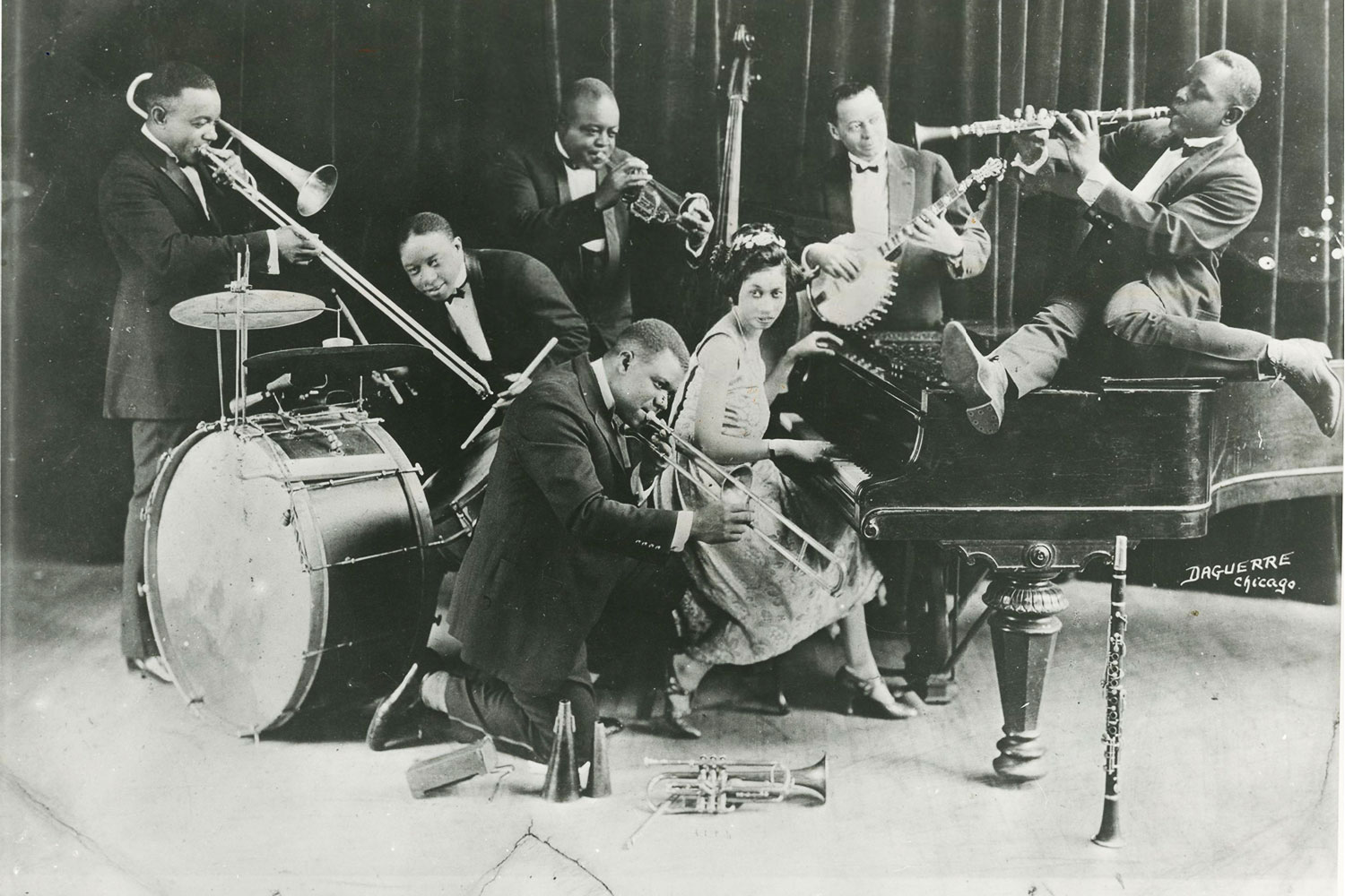 King Oliver’s Creole Jazz Band, circa 1923. Honore Dutrey, trombone; Warren “Baby” Dodds, drums; Joe Oliver, cornet; Louis Armstrong (kneeling in front), slide trumpet; Lil Hardin Armstrong, piano; Bill Johnson, banjo; Johnny Dodds, clarinet.