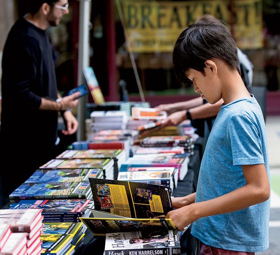 A kid looking through a book atPrinters Row Lit Fest