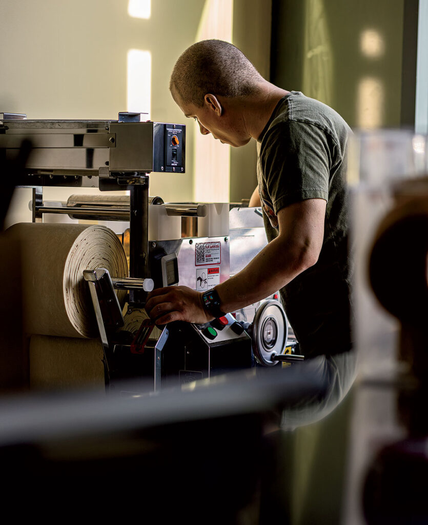 Satinover watches sheets of dough roll out of the Yamato Richmen noodle machine, looking for any tears or other imperfections.