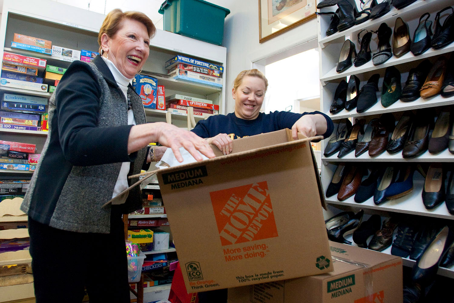 Manager Tillie Thorpe, left, and volunteer Audree Gee unpack donated boxes at the Treasure House.