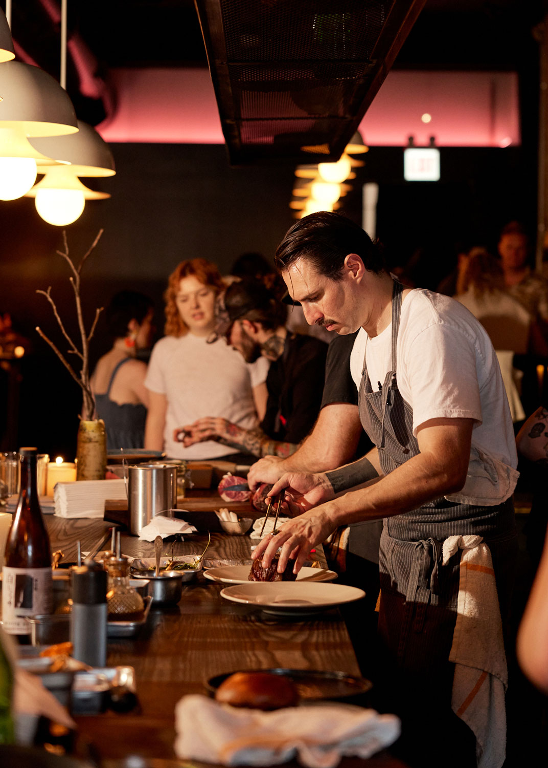 Cochef and partner Trevor Fleming preparing food at Warlord, with Julia Suhr in the background.