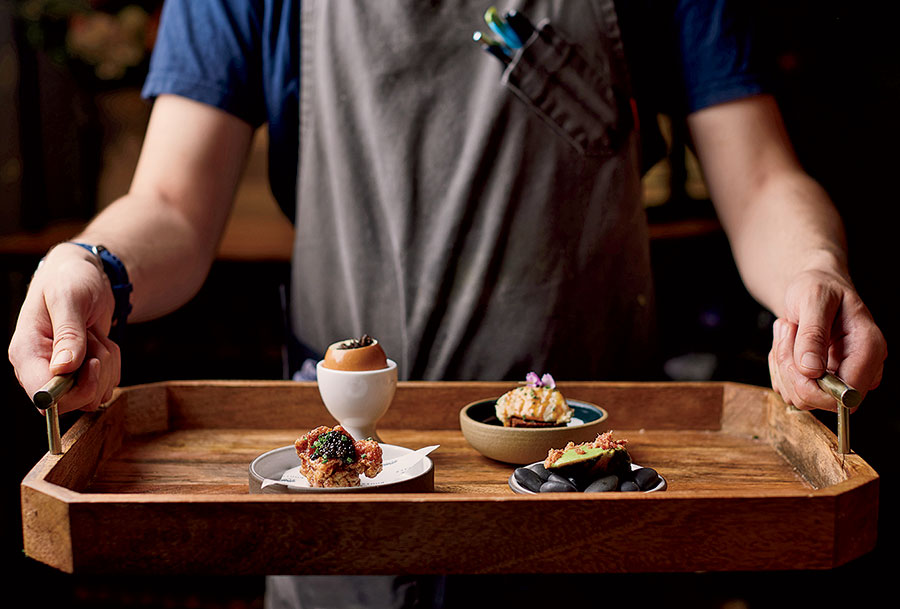 A chef holding a tray of food at Rootstalk