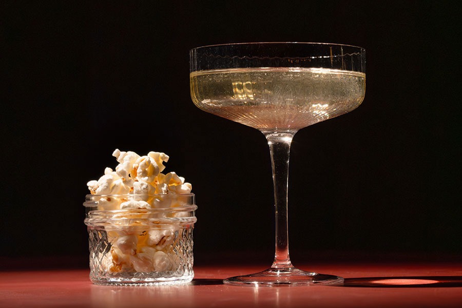 A cocktail and a cup of popcorn at Caché 310