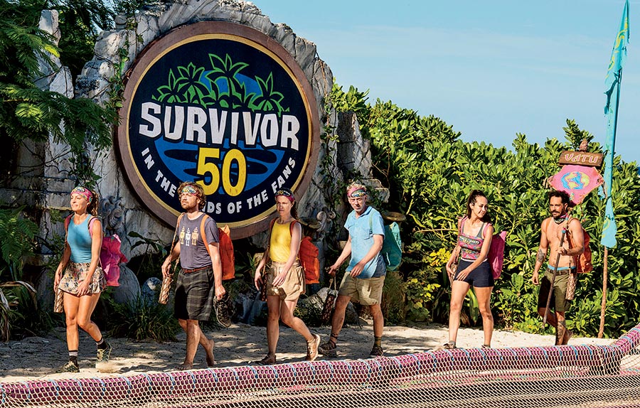 Contestants walking in front of the ’Survivor 50’ sign